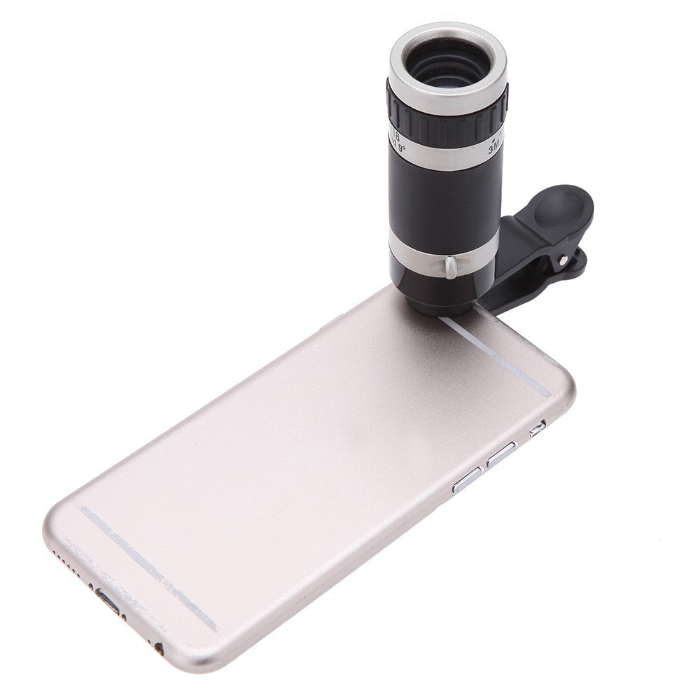 Phone with a clip-on telescope attachment on a white background
