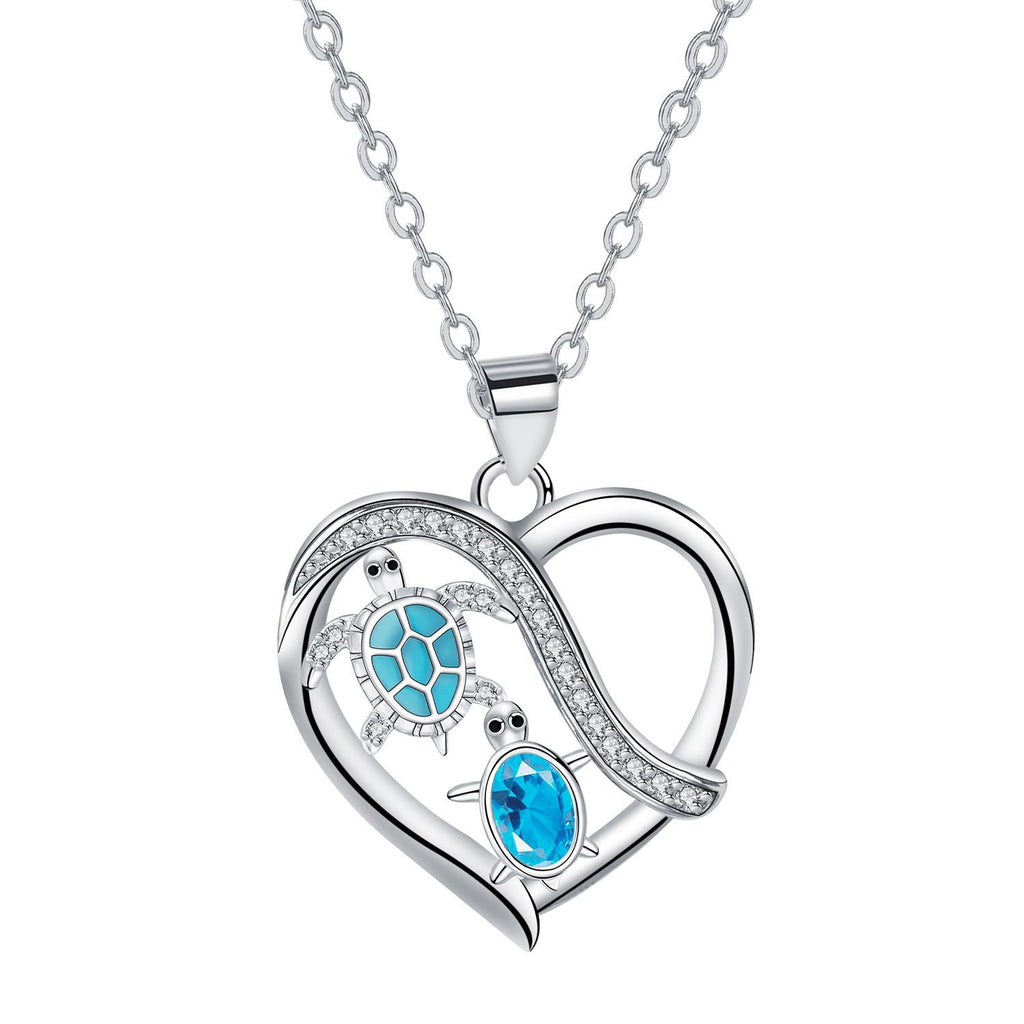 Heart-shaped pendant with turtle design and blue gemstones on a white background