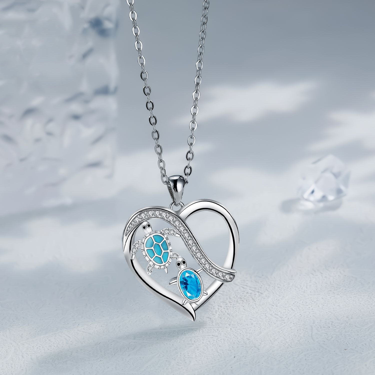 Heart-shaped silver necklace with blue gemstones on a soft gray background
