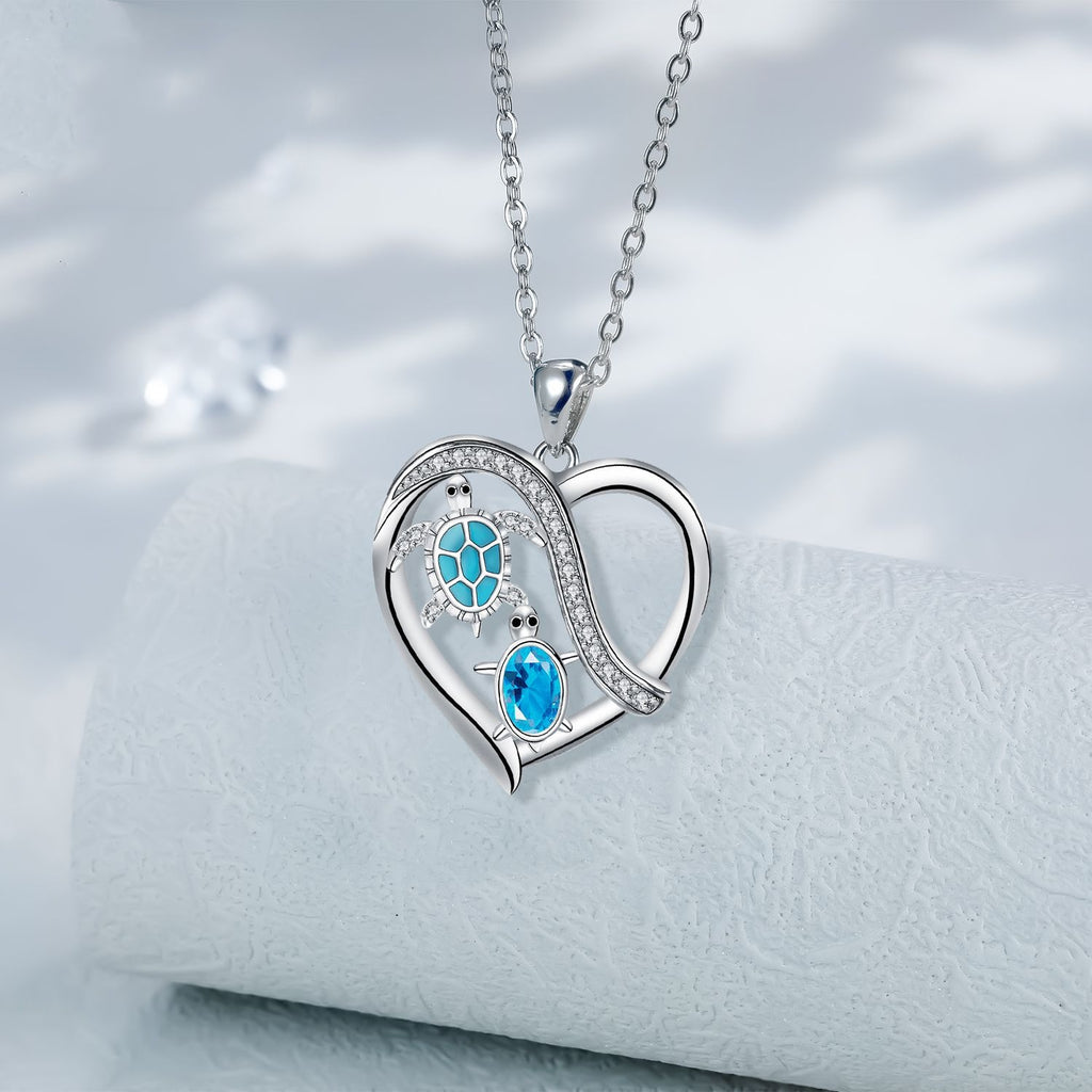 Heart-shaped silver necklace with blue gemstones on a white background